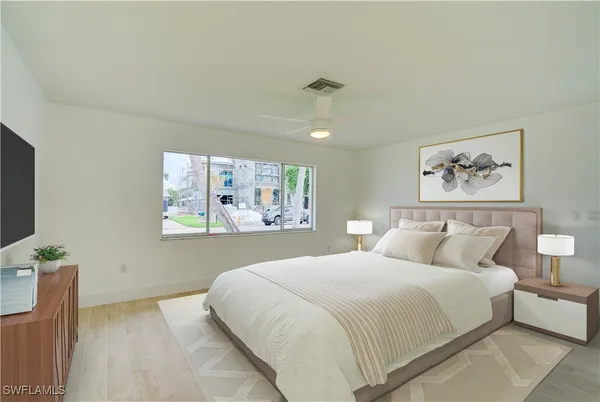 a bedroom with a large bed and a painting on the wall