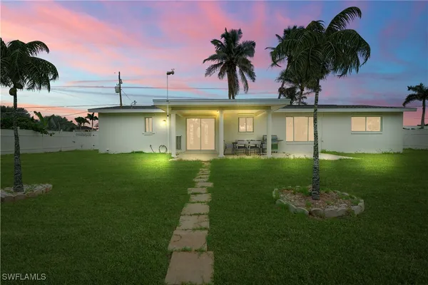 a view of a house with a swimming pool and a yard