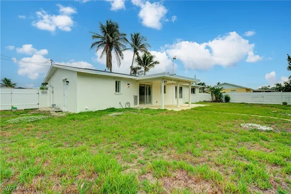 a view of a house with a swimming pool and a lawn chairs with plants