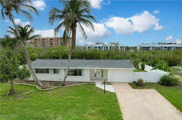 a backyard of a house with plants and palm trees