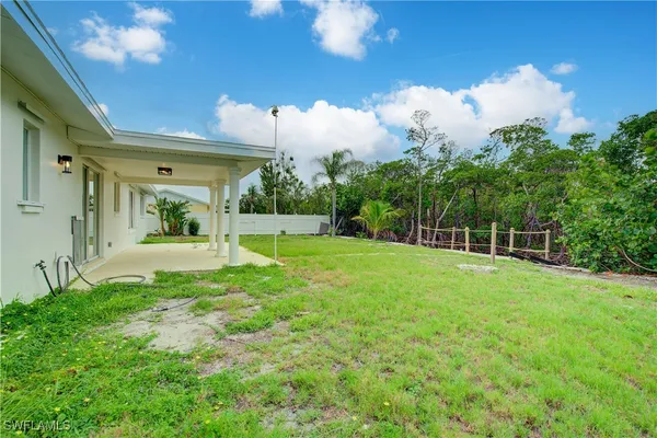 a front view of a house with a garden and trees