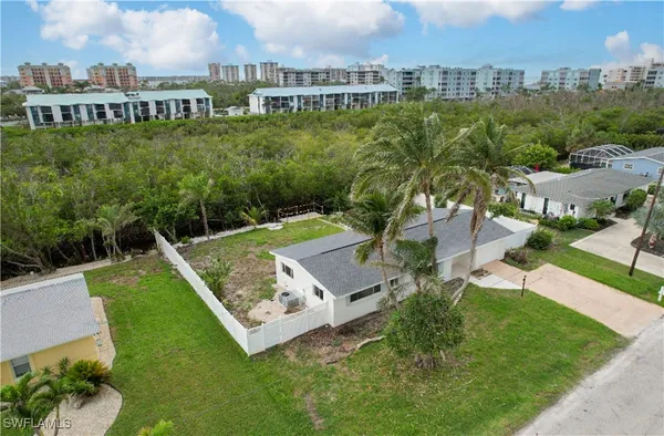 an aerial view of residential houses with outdoor space and trees