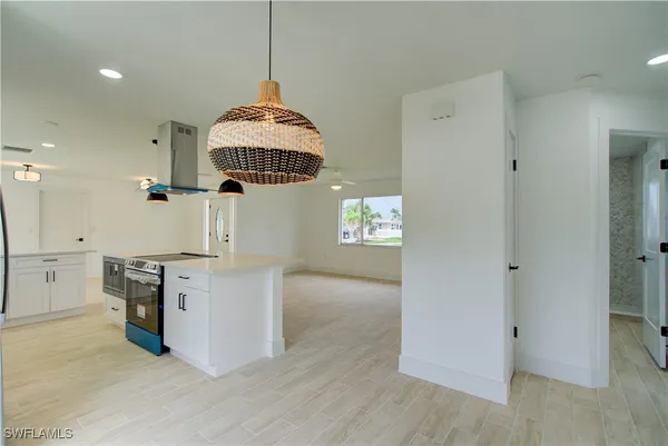 a hallway with cabinets stove and refrigerator
