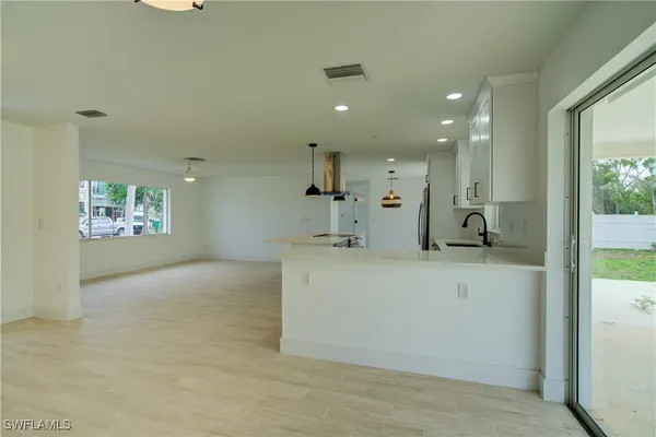 a view of kitchen with stainless steel appliances granite countertop a refrigerator and a sink