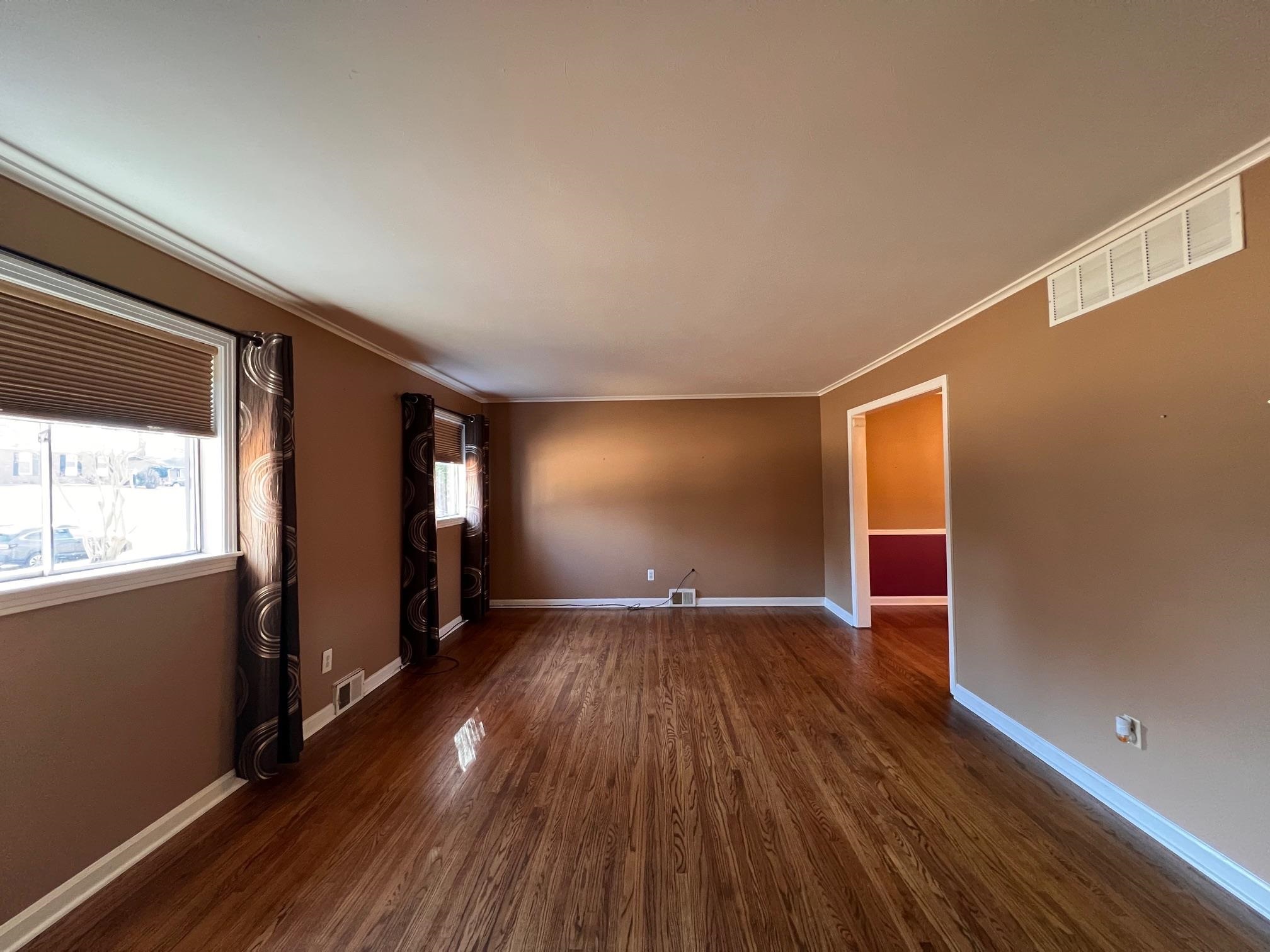 3034 Laurencekirk Road Memphis, TN 38128 - Photo 6 of 27 a view of an empty room with wooden floor and a window