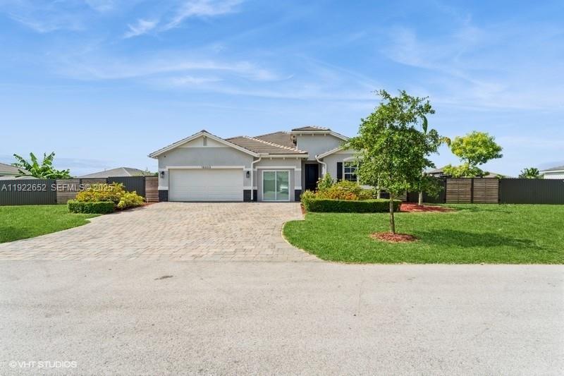 a front view of a house with a yard and trees