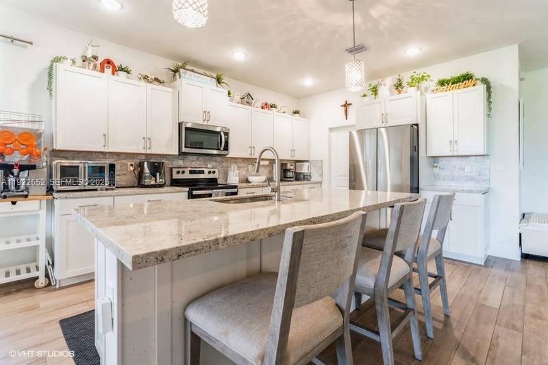 16033 Southwest 277th Street Homestead, FL 33031 - Photo 11 of 37 a kitchen with stainless steel appliances granite countertop a table chairs microwave and sink