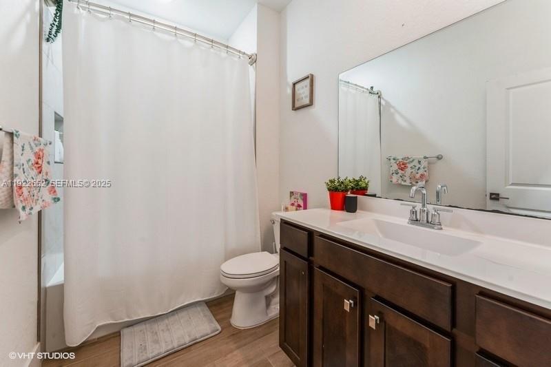 16033 Southwest 277th Street Homestead, FL 33031 - Photo 22 of 37 a bathroom with a sink a toilet and shower curtain