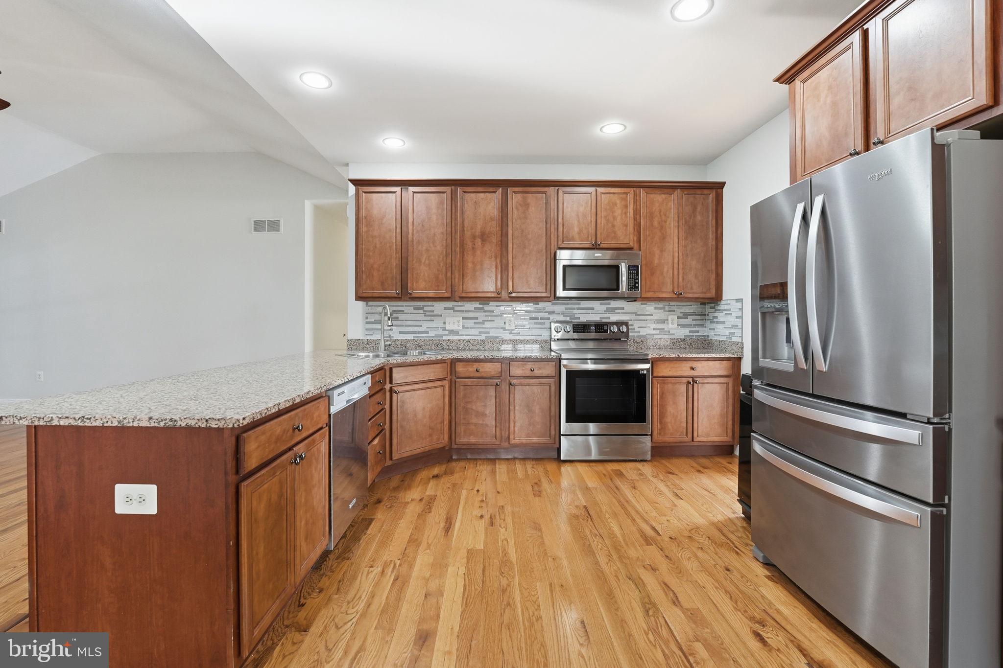 450 Canyon Road Winchester, VA 22602 - Photo 21 of 51 a kitchen with stainless steel appliances wooden floor sink refrigerator and microwave