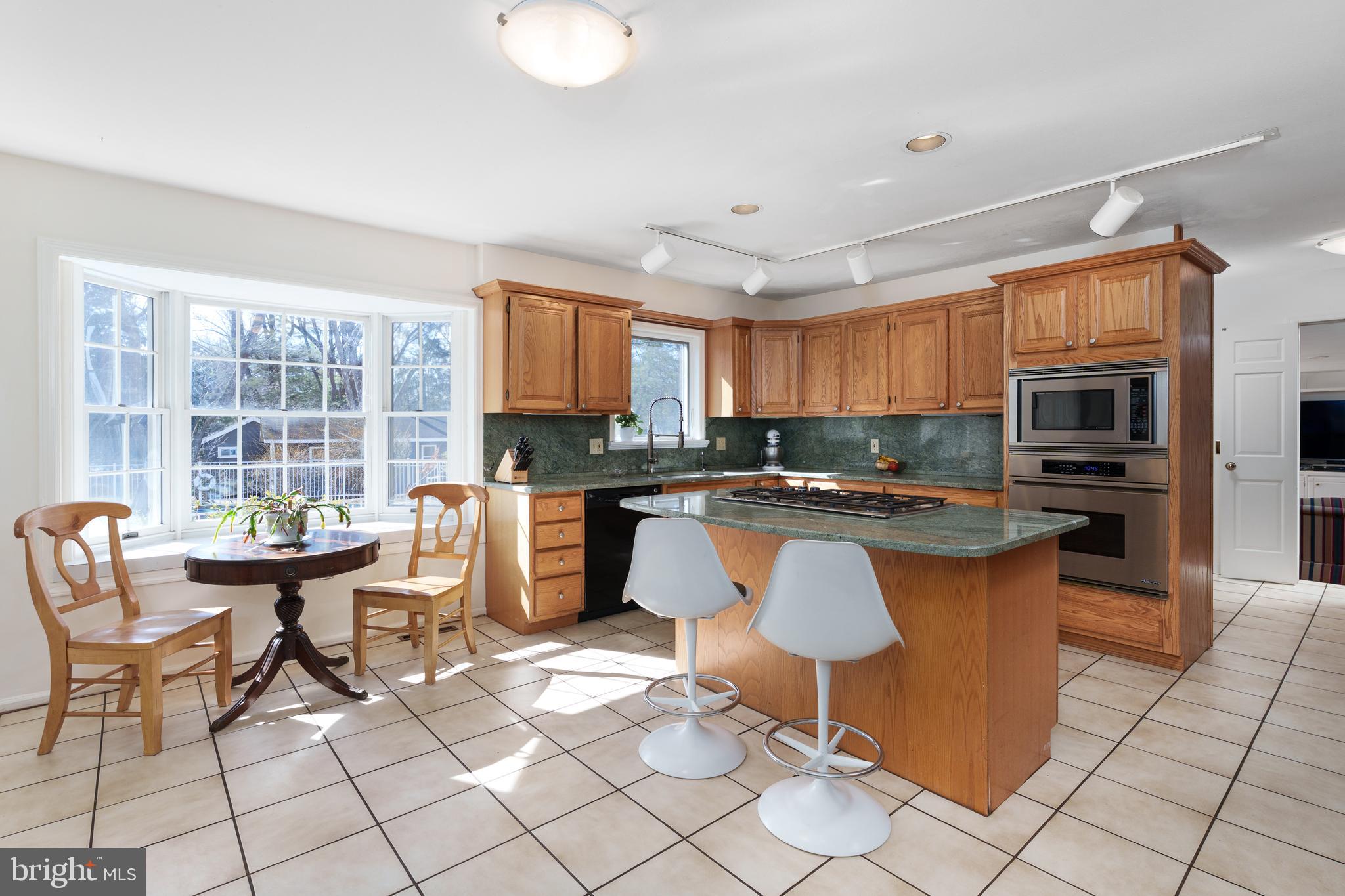 28 Talbot Lane Princeton, NJ 08540 - Photo 12 of 55 a kitchen with stainless steel appliances granite countertop a stove a sink a dining table and chairs