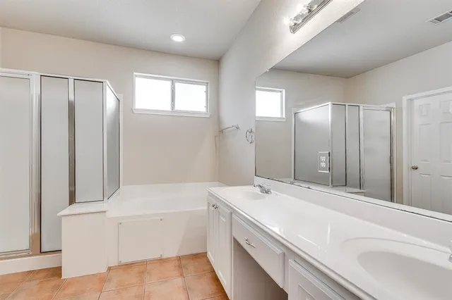 a bathroom with a tub a sink and mirror