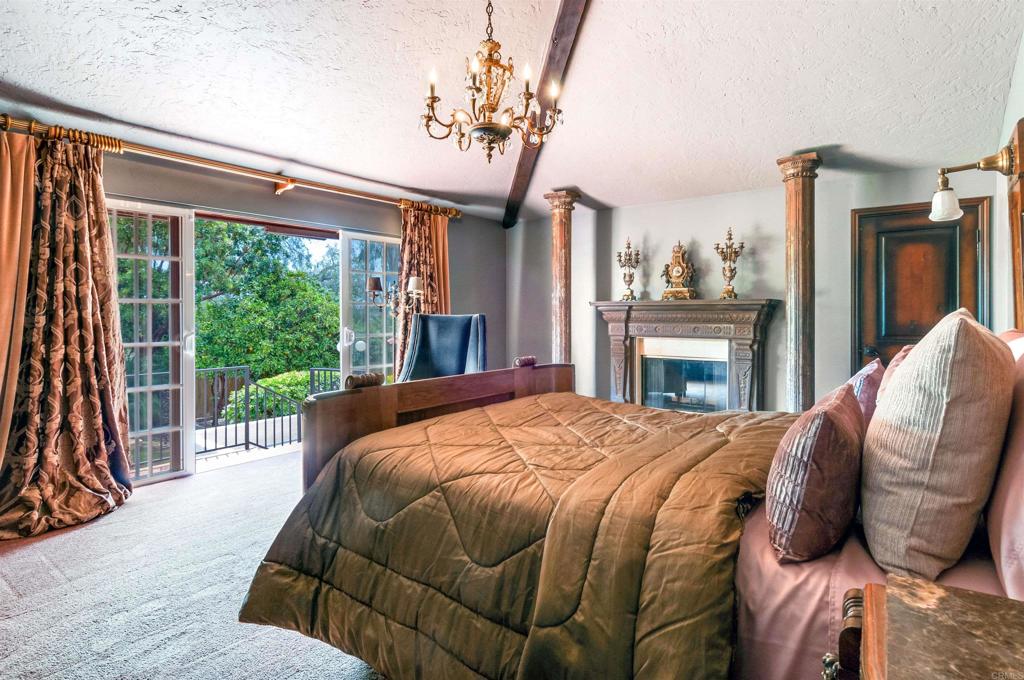 725 Hamilton Lane Fallbrook, CA 92028 - Photo 18 of 54 a bed sitting in a bedroom next to a window with a balcony fireplace