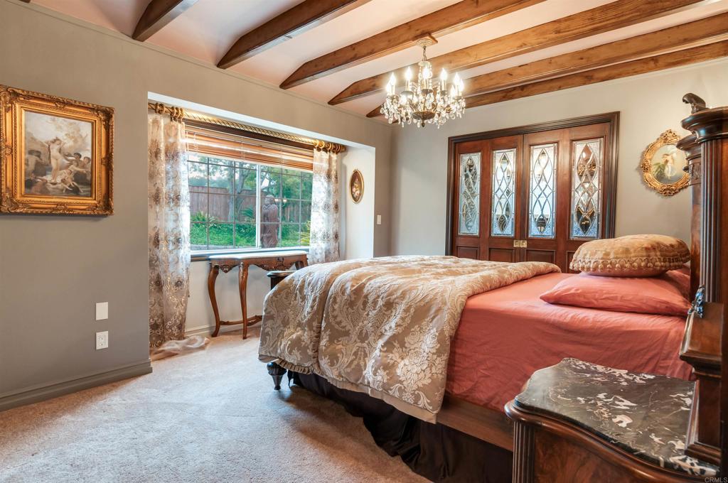 725 Hamilton Lane Fallbrook, CA 92028 - Photo 32 of 54 a spacious bedroom with a bed and a chandelier