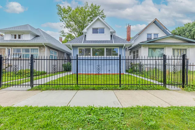 a view of a brick house with a big yard and plants
