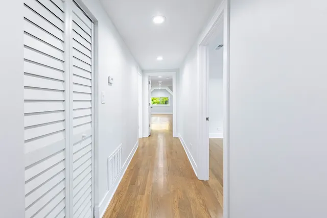 a view of a hallway with wooden floor and staircase