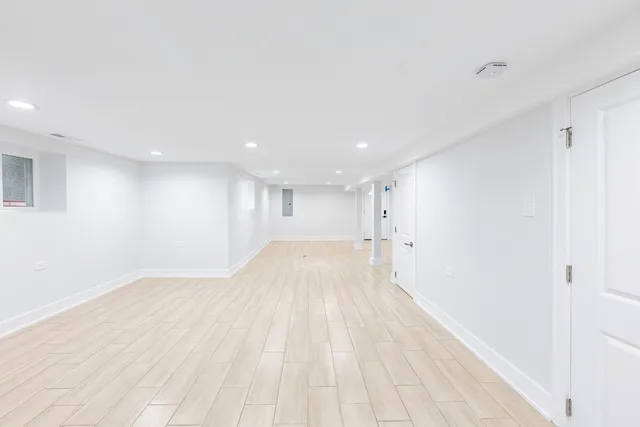 a view of empty room with wooden floor