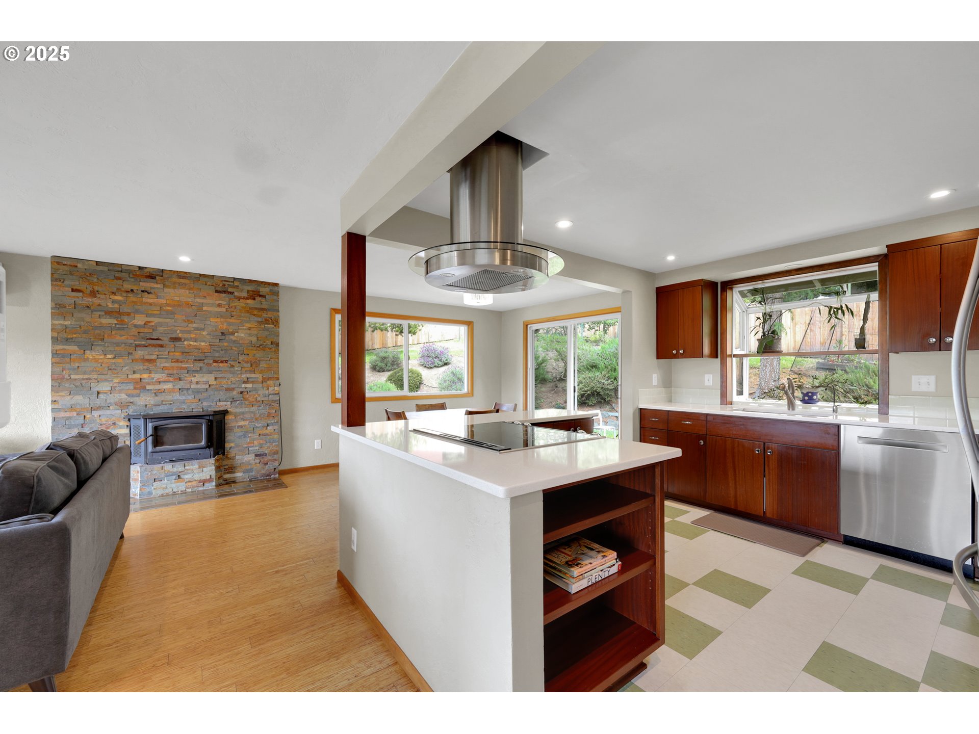 3765 Potter Street Eugene, OR 97405 - Photo 4 of 48 a kitchen with stainless steel appliances granite countertop a stove a sink dishwasher and a fireplace with wooden floor
