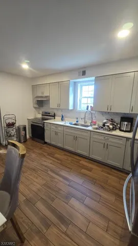 a kitchen with stainless steel appliances granite countertop a sink stove and cabinets