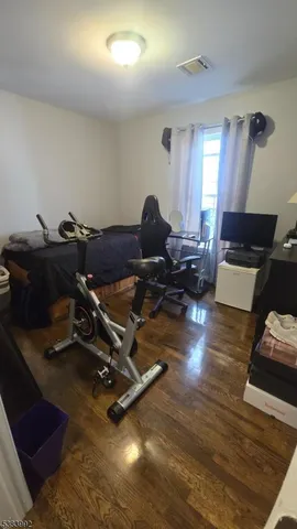 a living room with furniture gym equipment and a wooden floor
