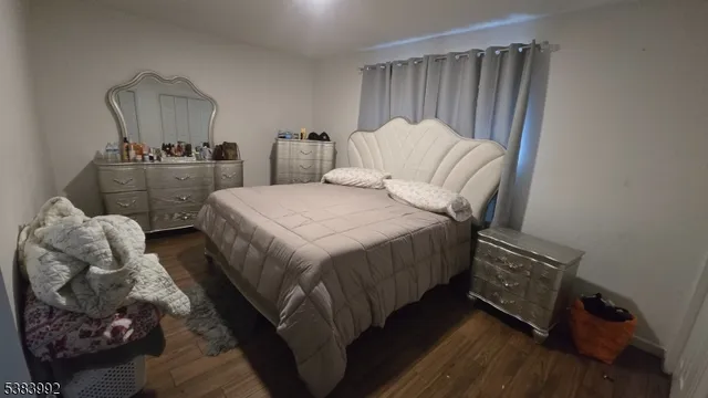 a bedroom with two beds and wooden floor