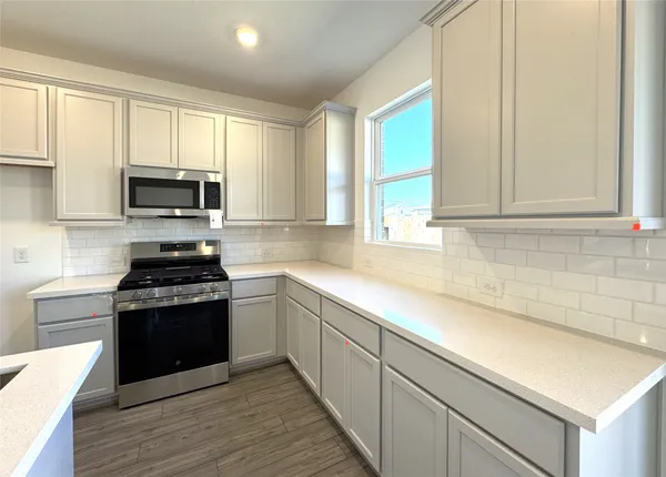 a kitchen with sink a stove and microwave
