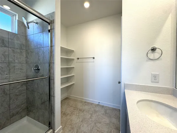 a bathroom with a granite countertop sink a toilet and shower