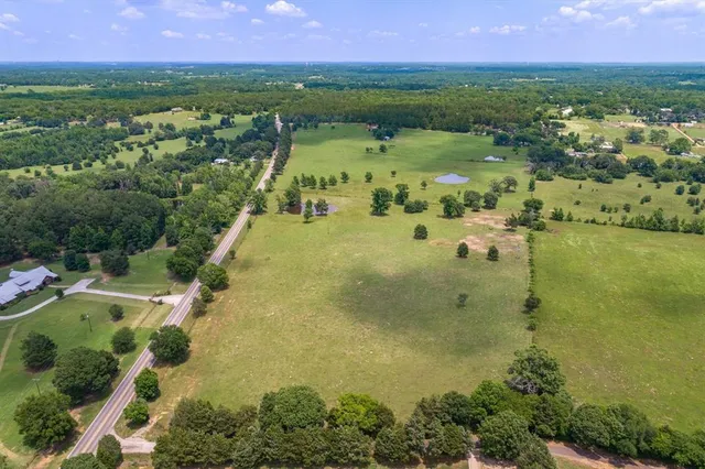 an aerial view of residential houses with outdoor space and trees