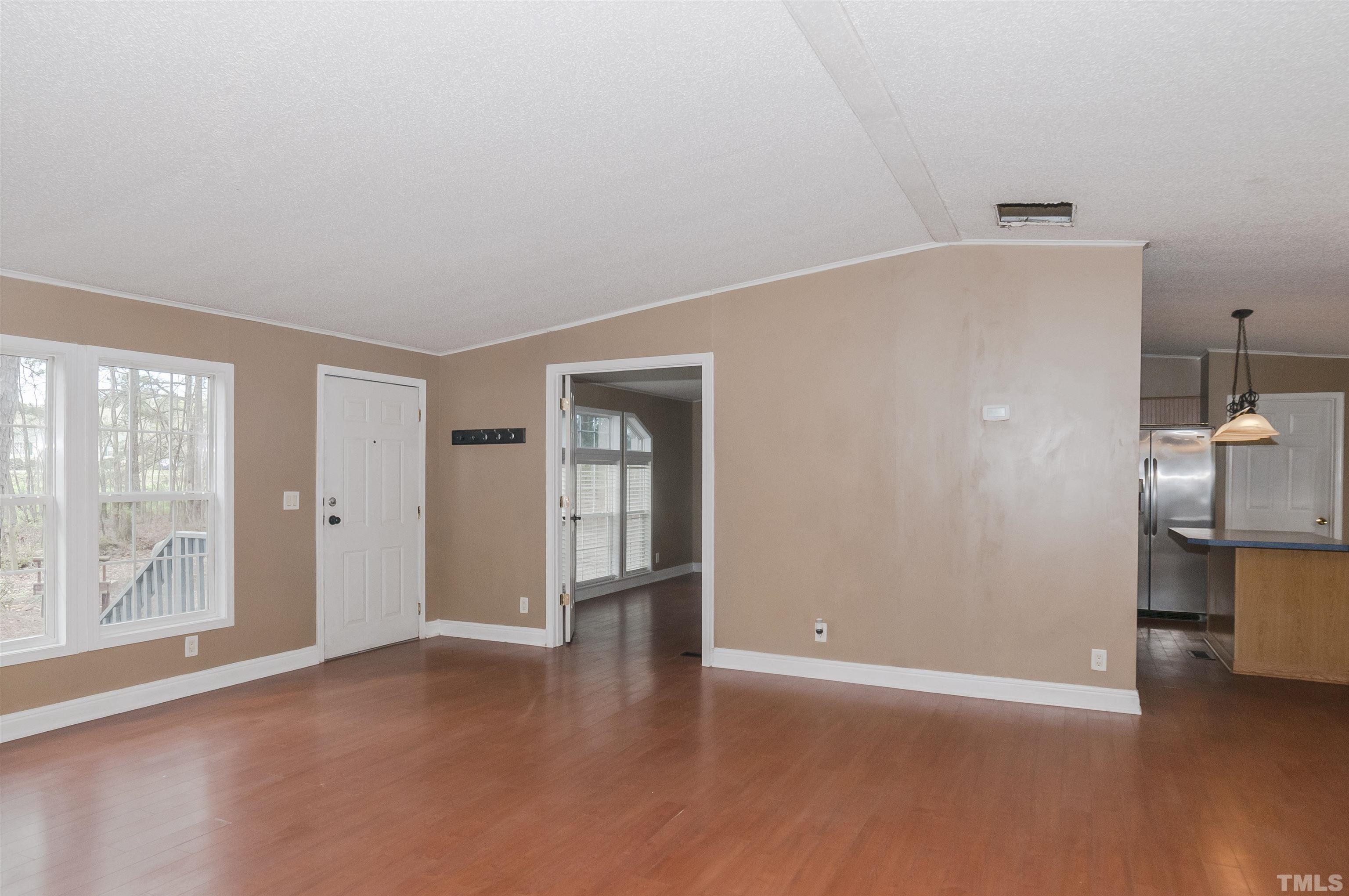 7909 Buffaloe Road Raleigh, NC 27616 - Photo 4 of 23 a view of an empty room with a window and wooden floor