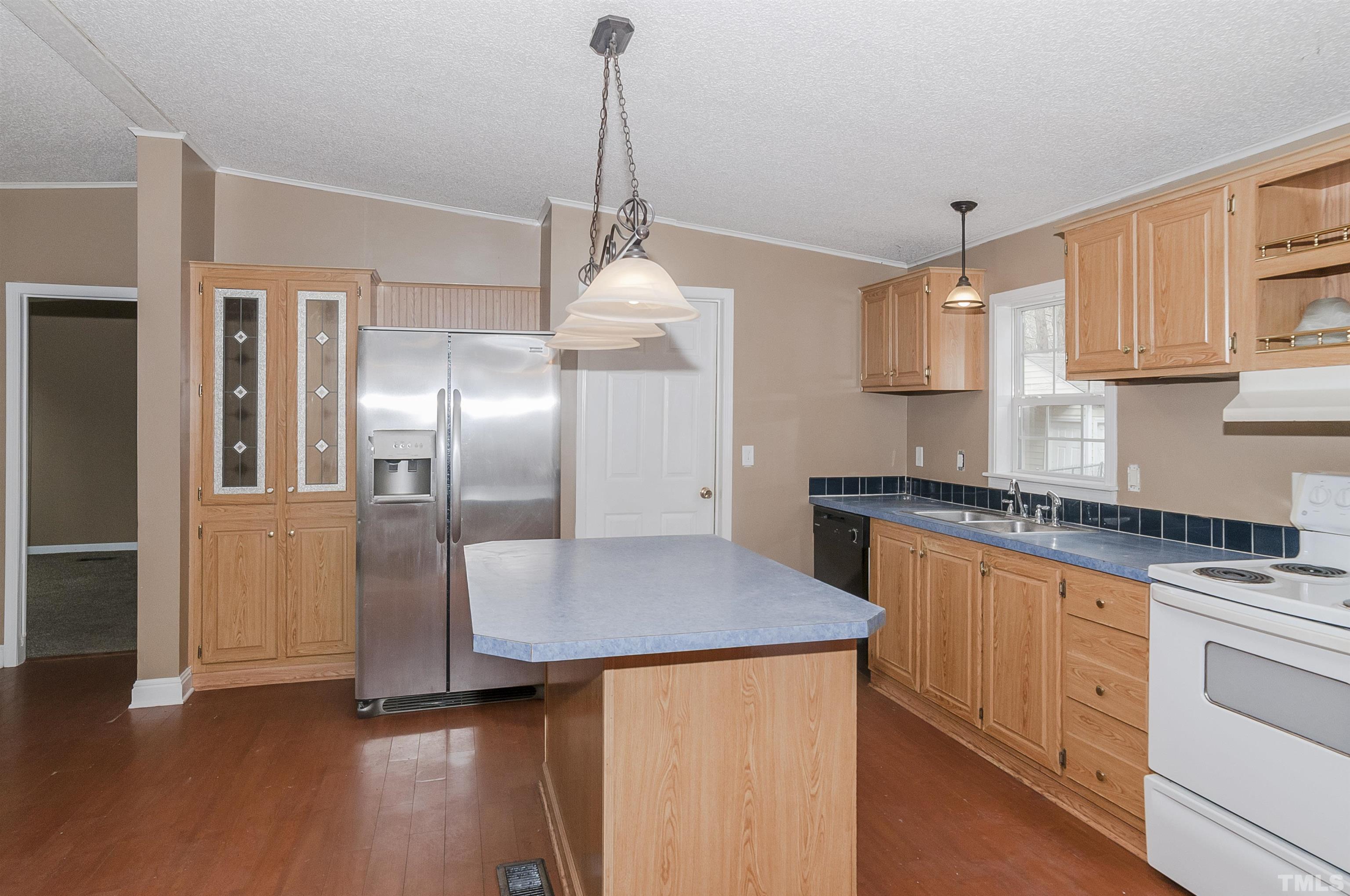 7909 Buffaloe Road Raleigh, NC 27616 - Photo 7 of 23 a kitchen with stainless steel appliances granite countertop a refrigerator a sink dishwasher a stove and white cabinets with wooden floor