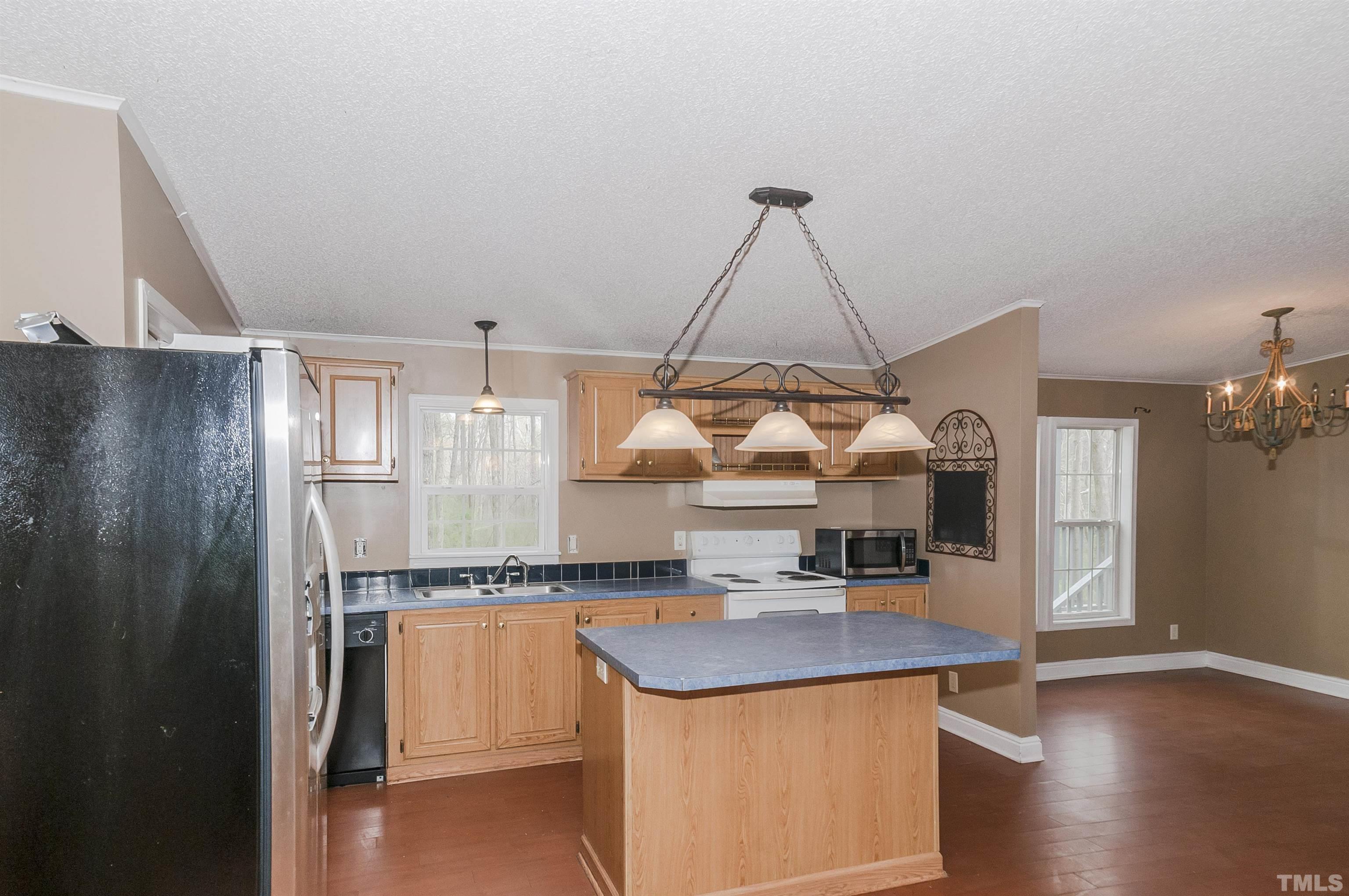 7909 Buffaloe Road Raleigh, NC 27616 - Photo 8 of 23 a kitchen with granite countertop a sink and a refrigerator