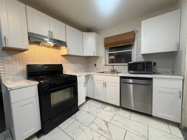 a kitchen with white cabinets and appliances