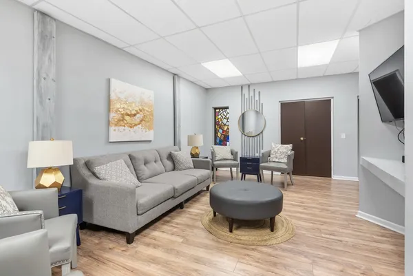 a living room with furniture a flat screen tv and kitchen view