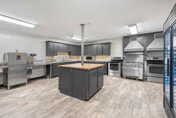 a kitchen with stainless steel appliances a stove top oven and refrigerator