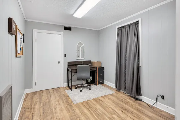 a view of a workspace with furniture and a window