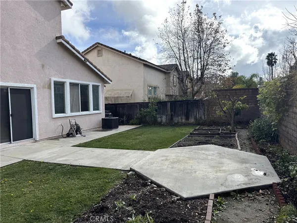 a backyard of a house with barbeque oven and outdoor seating