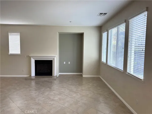 a view of an empty room with a fireplace and a window