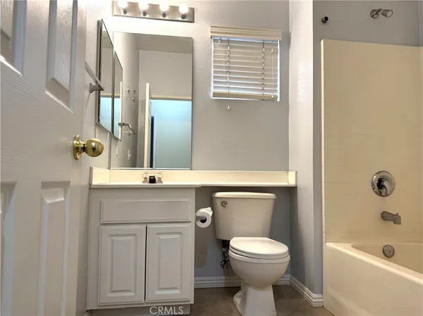 a bathroom with a granite countertop toilet sink and mirror
