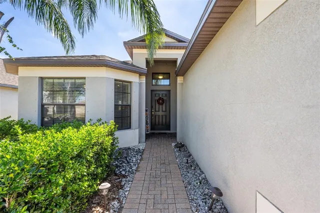 a view of a pathway of house with potted plants