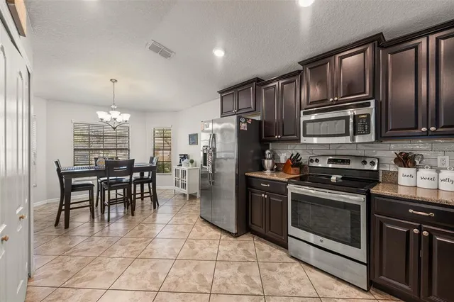 a kitchen with granite countertop a stove cabinets and stainless steel appliances