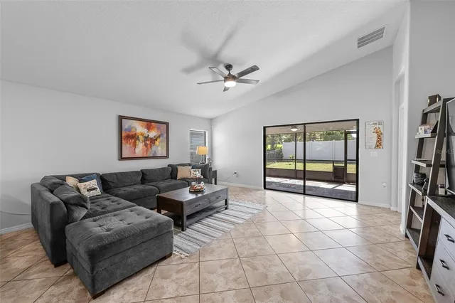 a living room with furniture a window and a ceiling fan