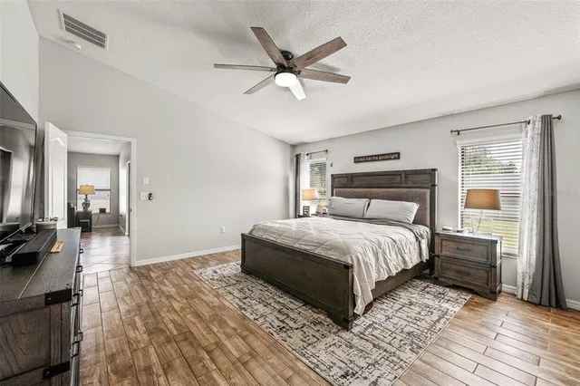 a bedroom with a large bed a chandelier and a window