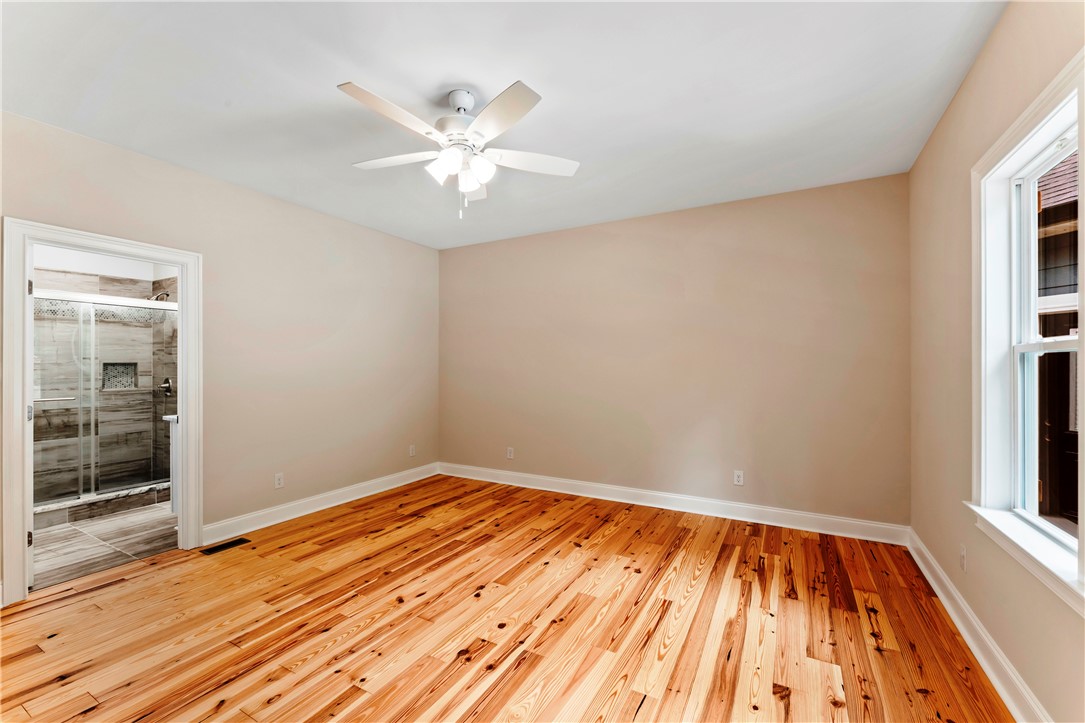 110 Gabriel Way Pickens, SC 29671 - Photo 16 of 48 Hardwood flooring extends throughout this generous room with an ensuite bathroom, featuring a modern ceiling fan for comfort.
