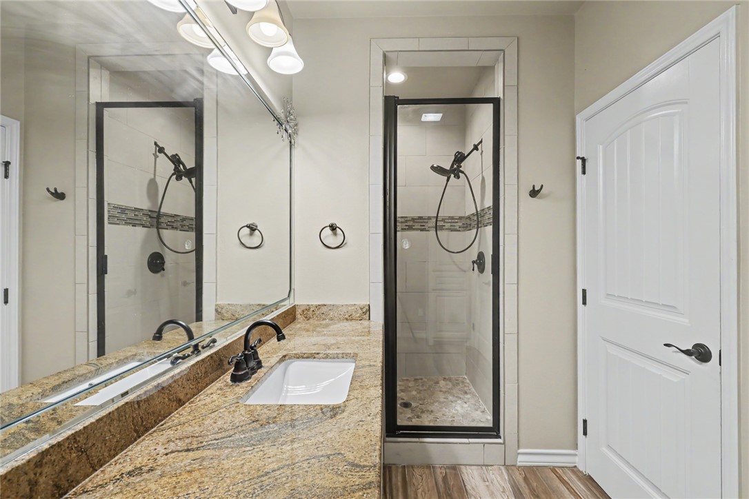 302 Cooper Road, Unit E2 Odem, TX 78370 - Photo 11 of 24 a bathroom with a granite countertop tub shower and mirror