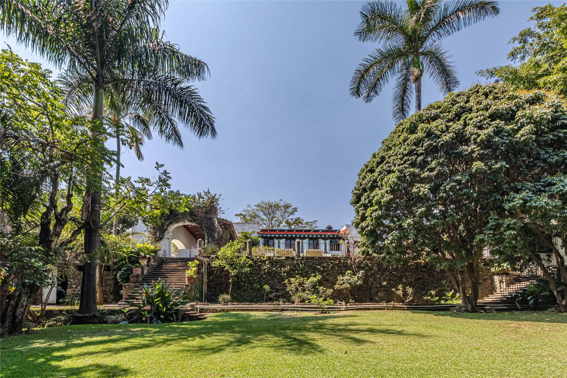 a front view of a house with swimming pool and trees