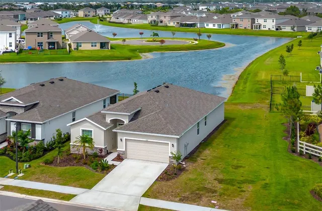 an aerial view of residential houses with outdoor space and swimming pool