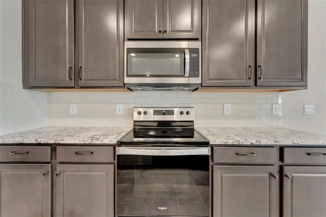 a kitchen with granite countertop stainless steel appliances and cabinets