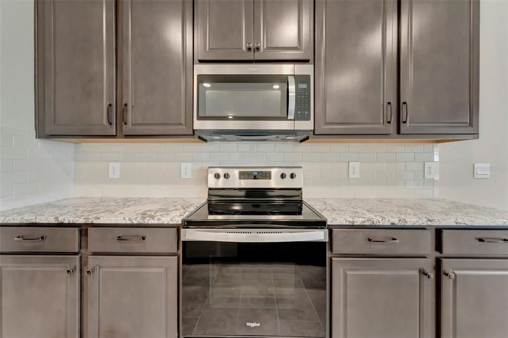 5210 Grove Mill Loop Lakewood Ranch, FL 34211 - Photo 11 of 48 a kitchen with granite countertop stainless steel appliances and cabinets
