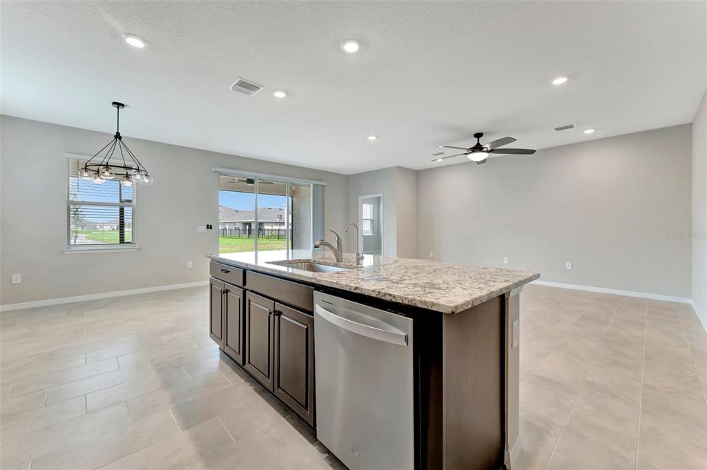 5210 Grove Mill Loop Lakewood Ranch, FL 34211 - Photo 12 of 48 a kitchen with granite countertop cabinets a sink dishwasher and a refrigerator