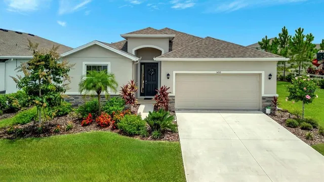 a front view of a house with a garden and plants
