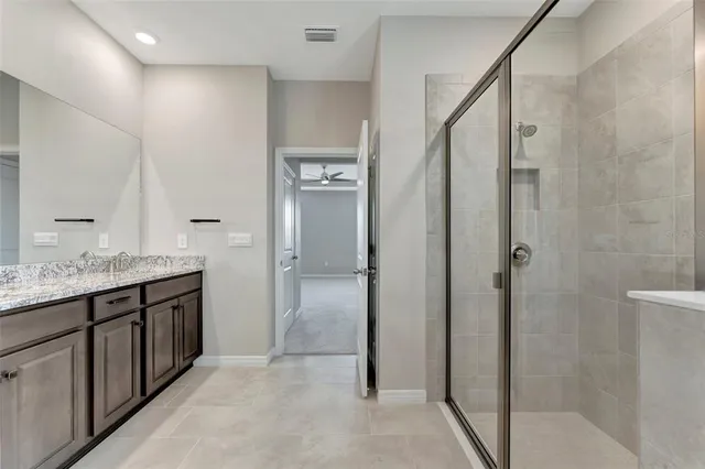 a bathroom with a granite countertop shower sink and mirror